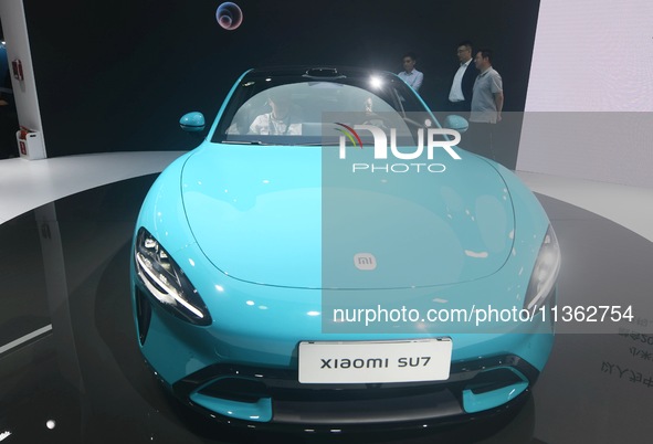 Foreign visitors are visiting the Xiaomi smart car SU7 at the 2024 Mobile World Congress (MWC Shanghai) in Shanghai, China, on June 26, 2024...