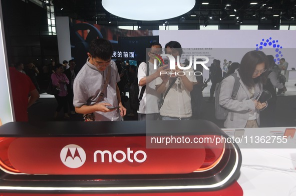 Foreign visitors are visiting the Xiaomi smart car SU7 at the 2024 Mobile World Congress (MWC Shanghai) in Shanghai, China, on June 26, 2024...