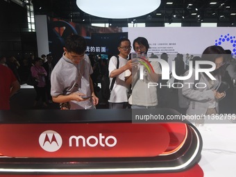 Foreign visitors are visiting the Xiaomi smart car SU7 at the 2024 Mobile World Congress (MWC Shanghai) in Shanghai, China, on June 26, 2024...