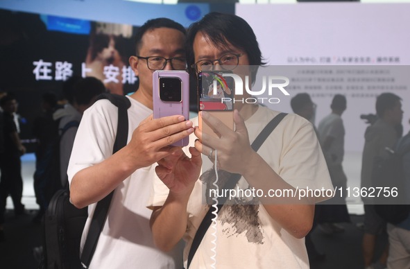 Foreign visitors are visiting the Xiaomi smart car SU7 at the 2024 Mobile World Congress (MWC Shanghai) in Shanghai, China, on June 26, 2024...