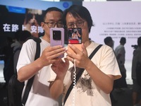 Foreign visitors are visiting the Xiaomi smart car SU7 at the 2024 Mobile World Congress (MWC Shanghai) in Shanghai, China, on June 26, 2024...