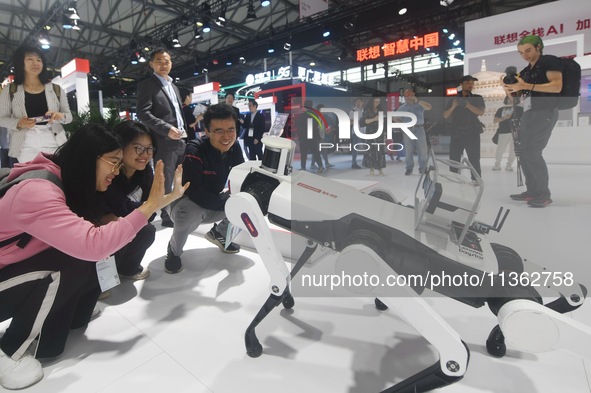 Foreign visitors are interacting with intelligent robot dogs at the 2024 Mobile World Congress (MWC Shanghai) in Shanghai, China, on June 26...