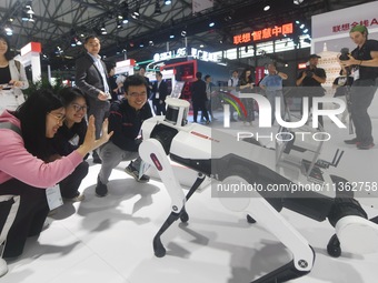 Foreign visitors are interacting with intelligent robot dogs at the 2024 Mobile World Congress (MWC Shanghai) in Shanghai, China, on June 26...