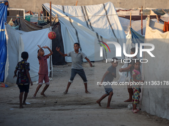 Displaced Palestinian children are playing football at a camp for displaced Palestinians in Deir al-Balah, in the central Gaza Strip, on Jun...