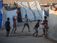 Displaced Palestinian children are playing football at a camp for displaced Palestinians in Deir al-Balah, in the central Gaza Strip, on Jun...