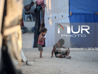 Displaced Palestinian children are playing at a camp for displaced Palestinians in Deir al-Balah, in the central Gaza Strip, on June 26, 202...