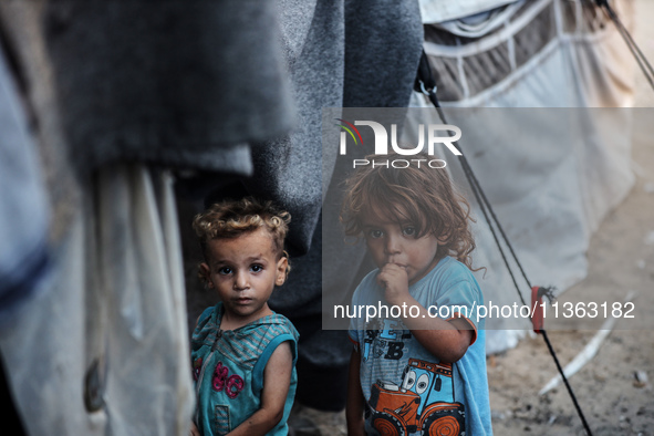 Displaced Palestinian children are staying at a camp for displaced Palestinians in Deir al-Balah, in the central Gaza Strip, on June 26, 202...