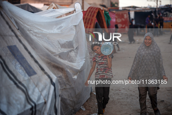 Displaced Palestinian girls are being seen at a camp for displaced Palestinians in Deir al-Balah, in the central Gaza Strip, on June 26, 202...