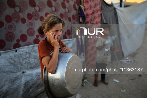 Displaced Palestinian girls are being seen at a camp for displaced Palestinians in Deir al-Balah, in the central Gaza Strip, on June 26, 202...