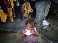 A displaced Palestinian girl is standing outside her tent at a camp for displaced Palestinians in Deir al-Balah, in the central Gaza Strip,...