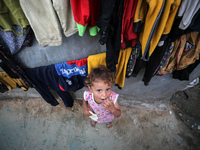 A displaced Palestinian girl is standing outside her tent at a camp for displaced Palestinians in Deir al-Balah, in the central Gaza Strip,...