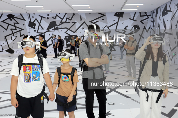 Visitors are experiencing a large-scale Space Exploration VR immersive exhibition in Suzhou, China, on June 26, 2024. 