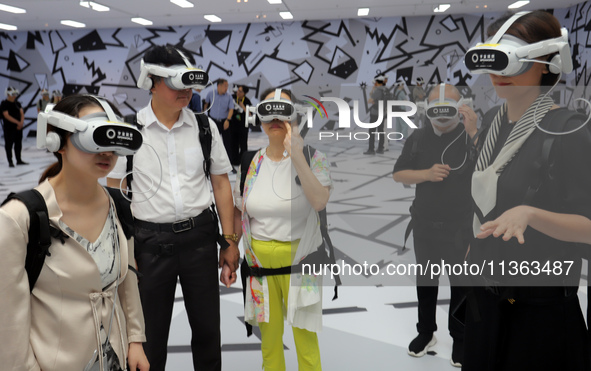 Visitors are experiencing a large-scale Space Exploration VR immersive exhibition in Suzhou, China, on June 26, 2024. 