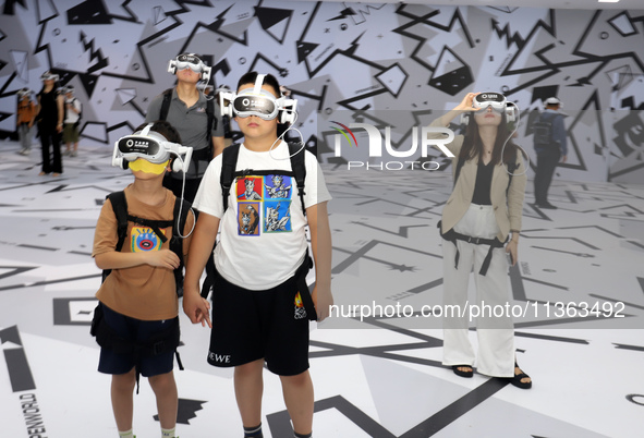 Visitors are experiencing a large-scale Space Exploration VR immersive exhibition in Suzhou, China, on June 26, 2024. 