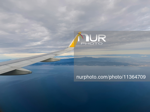 Clouds are appearing on the horizon, viewed from the window of an Airbus A321 from Vueling Airlines in Zurich, Switzerland, on June 27, 2024...