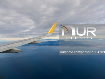 Clouds are appearing on the horizon, viewed from the window of an Airbus A321 from Vueling Airlines in Zurich, Switzerland, on June 27, 2024...