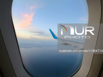 Clouds are appearing on the horizon, viewed from the window of an Airbus A321 from Vueling Airlines in Zurich, Switzerland, on June 27, 2024...