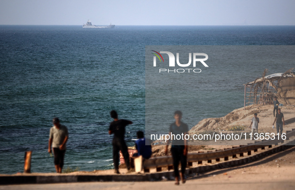 A ship is being pictured off the coast of Gaza near a temporary floating pier anchored by the United States to boost aid deliveries, as seen...