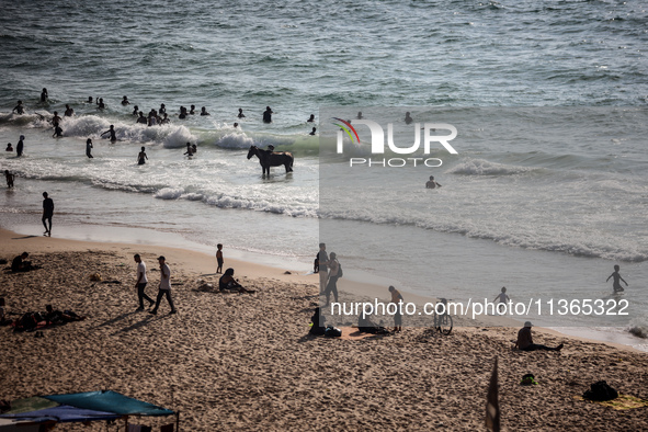 Palestinians are gathering on the beach in Nuseirat in the central Gaza Strip on June 27, 2024, amid ongoing cross-border tensions as fighti...