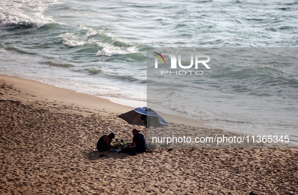 Palestinians are gathering on the beach in Nuseirat in the central Gaza Strip on June 27, 2024, amid ongoing cross-border tensions as fighti...