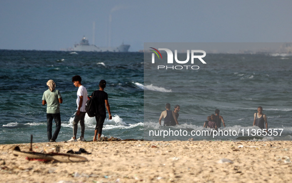 A ship is being pictured off the coast of Gaza near a temporary floating pier anchored by the United States to boost aid deliveries, as seen...