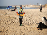 A Palestinian girl is selling candied apples as Palestinians are spending time at the beach on a hot summer day in Nuseirat in the central G...