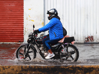 A person is riding a motorcycle on a flooded street in the municipality of Nezahualcoyotl due to the heavy rains recorded yesterday in Mexic...