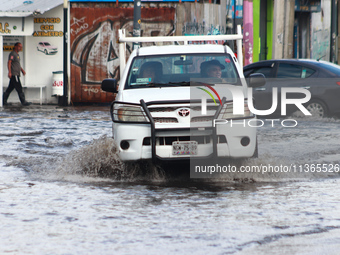 A driver is crossing a flooded street in the municipality of Nezahualcoyotl due to the heavy rains recorded yesterday, on June 27, 2024, in...