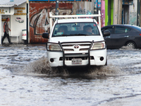 A driver is crossing a flooded street in the municipality of Nezahualcoyotl due to the heavy rains recorded yesterday, on June 27, 2024, in...