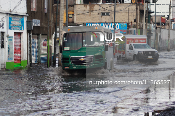 A public transport driver is crossing a flooded street in the municipality of Nezahualcoyotl due to the heavy rains recorded yesterday in Me...