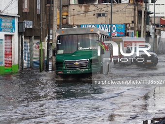 A public transport driver is crossing a flooded street in the municipality of Nezahualcoyotl due to the heavy rains recorded yesterday in Me...