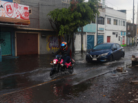 A person is riding a motorcycle on a flooded street in the municipality of Nezahualcoyotl due to the heavy rains recorded yesterday in Mexic...