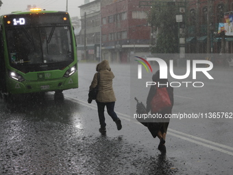 People are running under heavy rains on the Calzada Ermita south of the city, due to Tropical Wave Number 5, which is hitting Mexico. Due to...