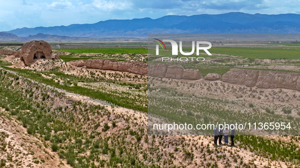 Workers are conducting an on-site survey and data collection of trenches and walls at the narrowest part of the Great Wall of the Han and Mi...