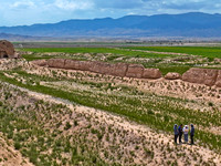 Workers are conducting an on-site survey and data collection of trenches and walls at the narrowest part of the Great Wall of the Han and Mi...