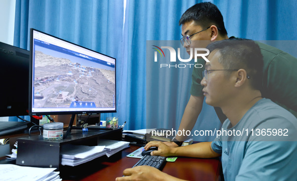 Staff members of the Han Ming Great Wall Protection and Research Center are using a 3D digital platform on a computer to measure the Great W...