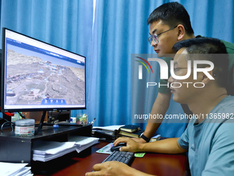 Staff members of the Han Ming Great Wall Protection and Research Center are using a 3D digital platform on a computer to measure the Great W...