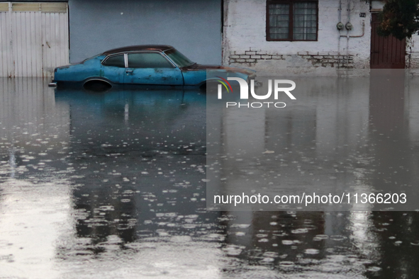 A car is being seen submerged above the tires due to the heavy rains that are hitting Mexico. Vicente Villada Avenue in the Municipality of...