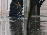 A woman is trying to walk with water above her knees on Vicente Villada Avenue, which is flooded due to heavy rains in the Municipality of N...