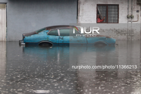 An old woman is looking at a car submerged due to the heavy rains that are hitting Mexico. Vicente Villada Avenue in the Municipality of Nez...