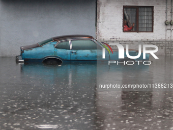 An old woman is looking at a car submerged due to the heavy rains that are hitting Mexico. Vicente Villada Avenue in the Municipality of Nez...