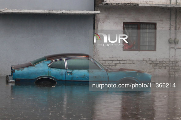 An old woman is looking at a car submerged due to the heavy rains that are hitting Mexico. Vicente Villada Avenue in the Municipality of Nez...