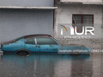 An old woman is looking at a car submerged due to the heavy rains that are hitting Mexico. Vicente Villada Avenue in the Municipality of Nez...