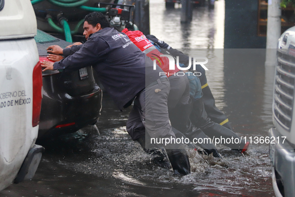 Municipality workers are pushing a stranded vehicle due to the heavy rains that are hitting Mexico. Vicente Villada Avenue in the Municipali...