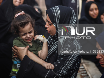 Mourners are reacting during the funeral of Palestinians killed in Israeli strikes, amid the Israel-Hamas conflict, at Al-Aqsa hospital in D...