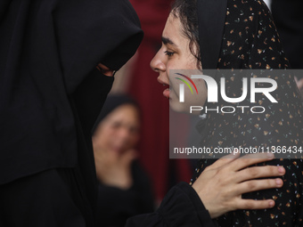 A mourner is reacting during the funeral of Palestinians killed in Israeli strikes, amid the Israel-Hamas conflict, at Al-Aqsa hospital in D...