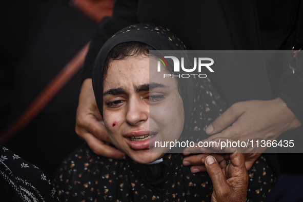 A mourner is reacting during the funeral of Palestinians killed in Israeli strikes, amid the Israel-Hamas conflict, at Al-Aqsa hospital in D...