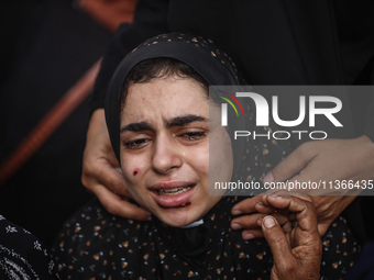 A mourner is reacting during the funeral of Palestinians killed in Israeli strikes, amid the Israel-Hamas conflict, at Al-Aqsa hospital in D...