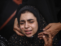 A mourner is reacting during the funeral of Palestinians killed in Israeli strikes, amid the Israel-Hamas conflict, at Al-Aqsa hospital in D...