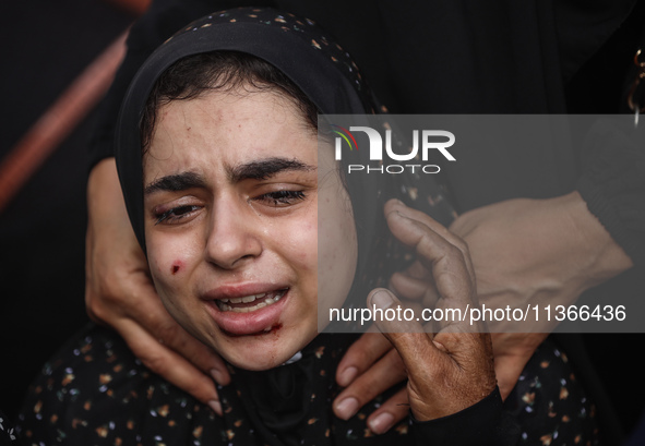 A mourner is reacting during the funeral of Palestinians killed in Israeli strikes, amid the Israel-Hamas conflict, at Al-Aqsa hospital in D...